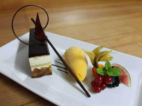 Tellerdessert mit Mango-Sorbet, Schokoladenschnitte, Johannisbeeren, Feige und Minze